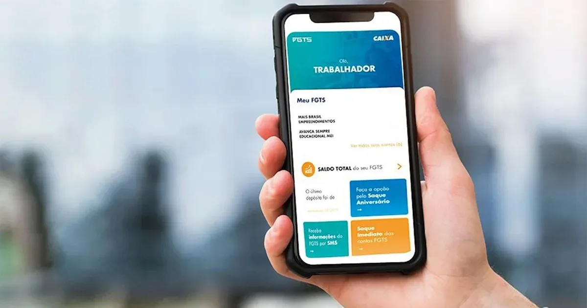 Pessoa segurando um smartphone que exibe a tela inicial do aplicativo do FGTS da Caixa Econômica Federal, com destaque para a opção de "Saque Aniversário".
