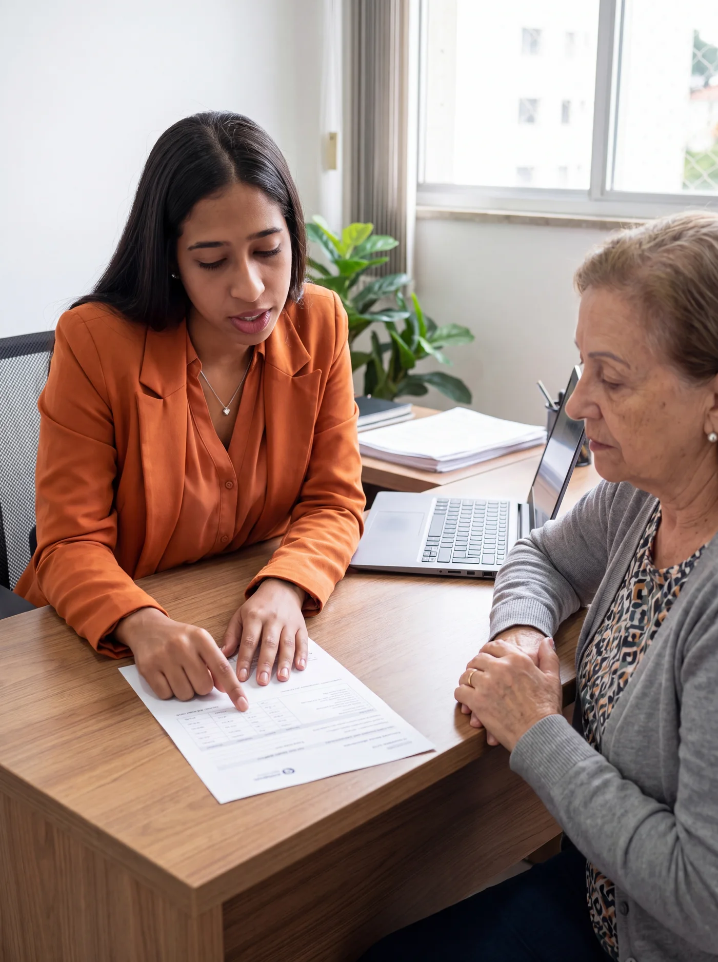 Duas mulheres conversando sobre um documento durante um atendimento.